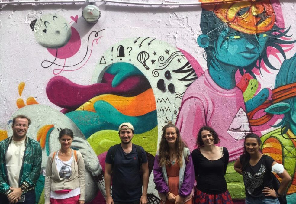 Certified Tour Guide in Berlin leading a group tour at colorful Berlin street art mural